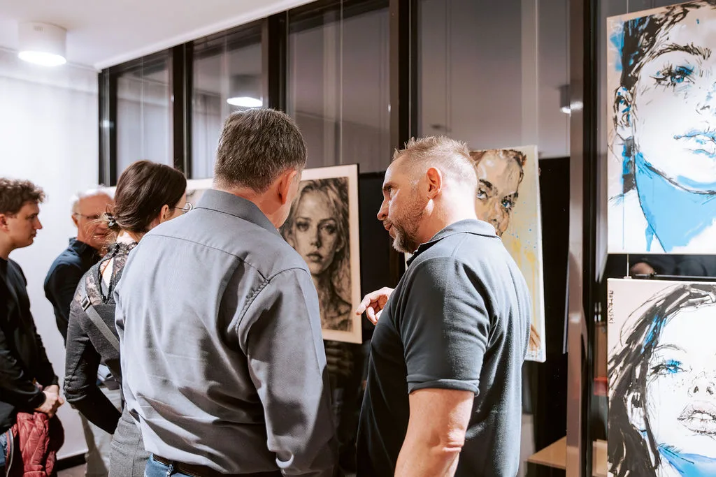 Pietrowski im Gespräch mit Besuchern vor den Portraits